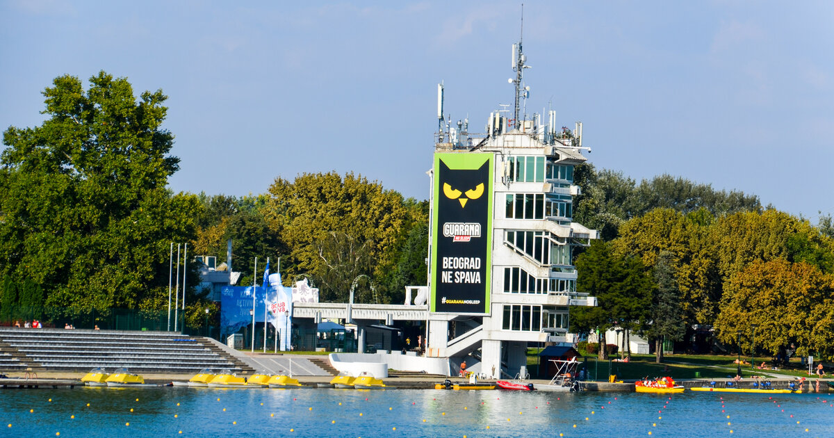 Waterfront tower with a large billboard, dock, and lake at Ada Ciganlija in Belgrade