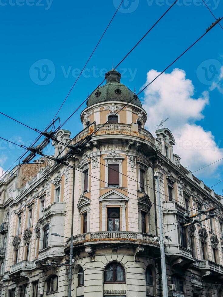 Ornate corner building with a dome and tram wires in Belgrade against a blue sky
