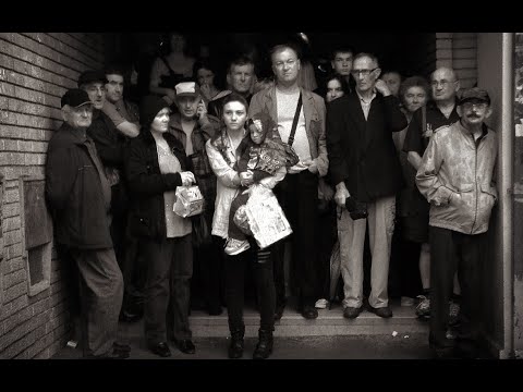 Group of people standing on steps in a doorway, including a woman holding a child