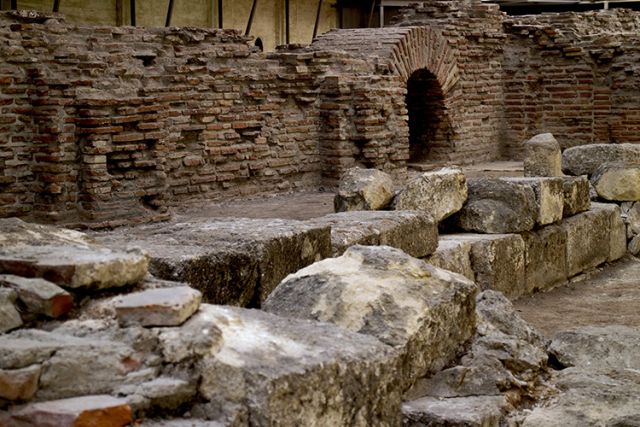 Brick and stone ruins with an arched opening at the Imperial Palace of Sirmium