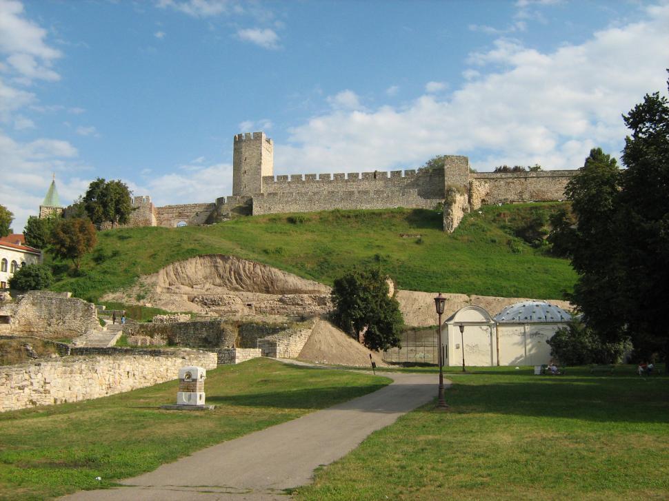 Stone fortress walls and a square tower above grassy slopes at Kalemegdan in Belgrade