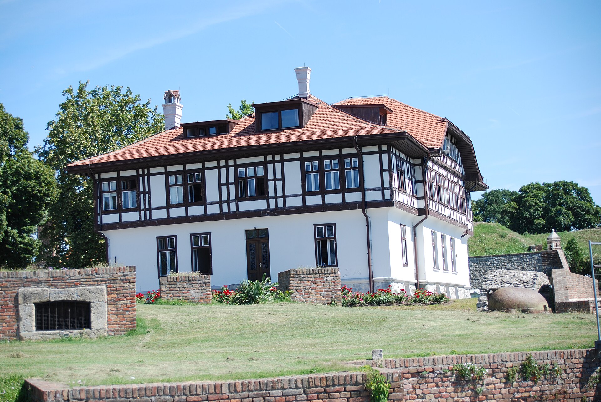 Timber-framed historic house inside Kalemegdan Fortress with stone walls and grassy ramparts