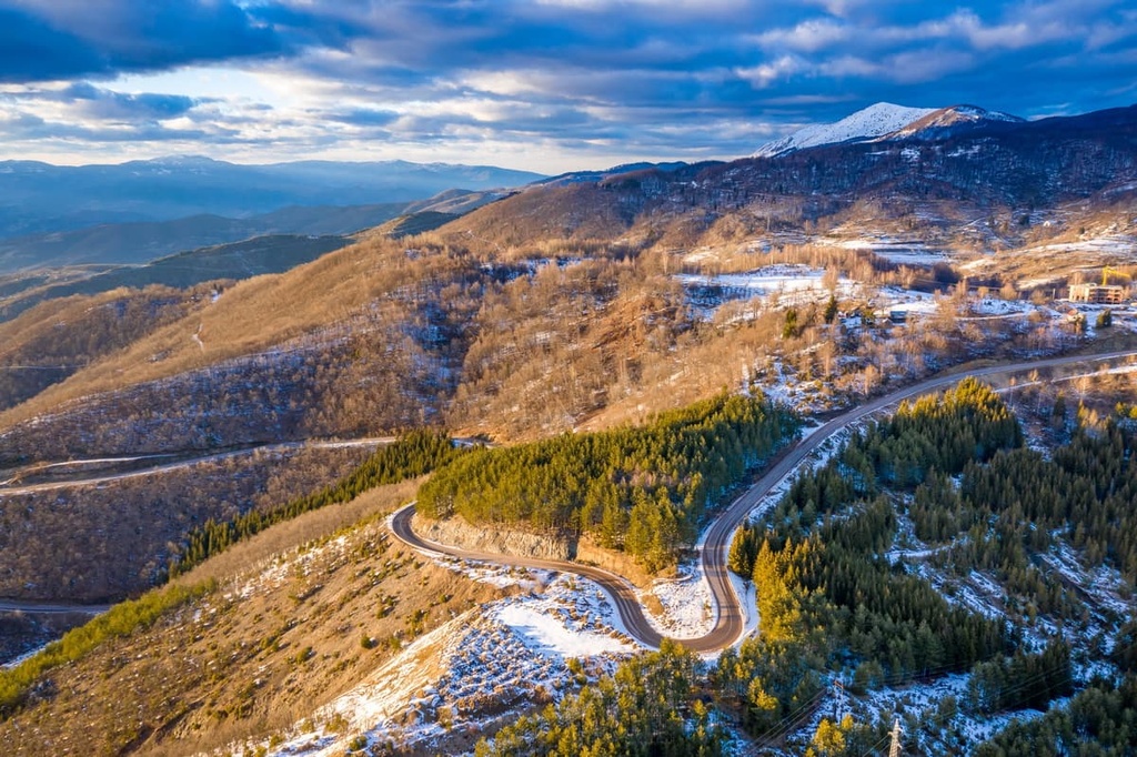 Winding mountain road through snowy forested slopes in Kopaonik National Park