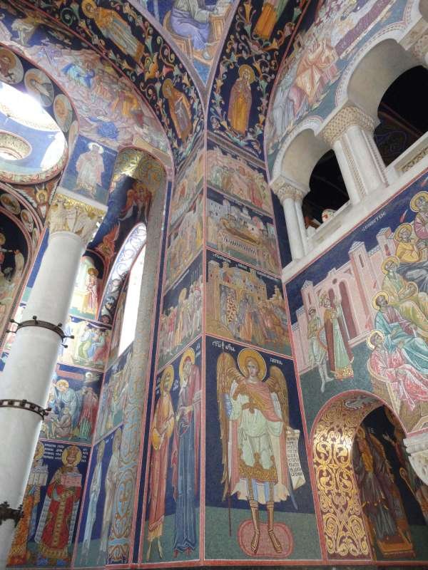 Orthodox church interior with painted frescoes, arched windows, and white columns in Kragujevac