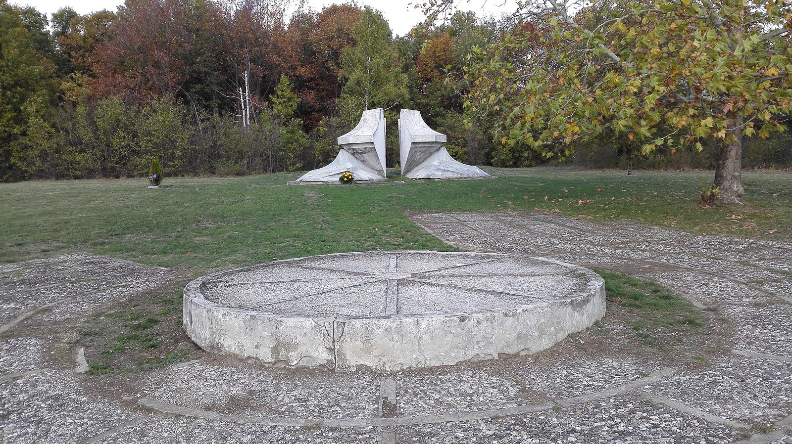 Abstract concrete memorial sculpture in a wooded park in Kragujevac