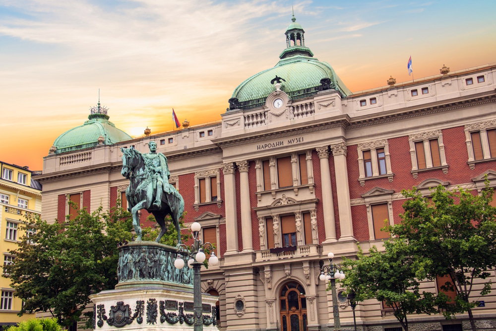 National Museum in Belgrade facade with an equestrian statue in front at sunset