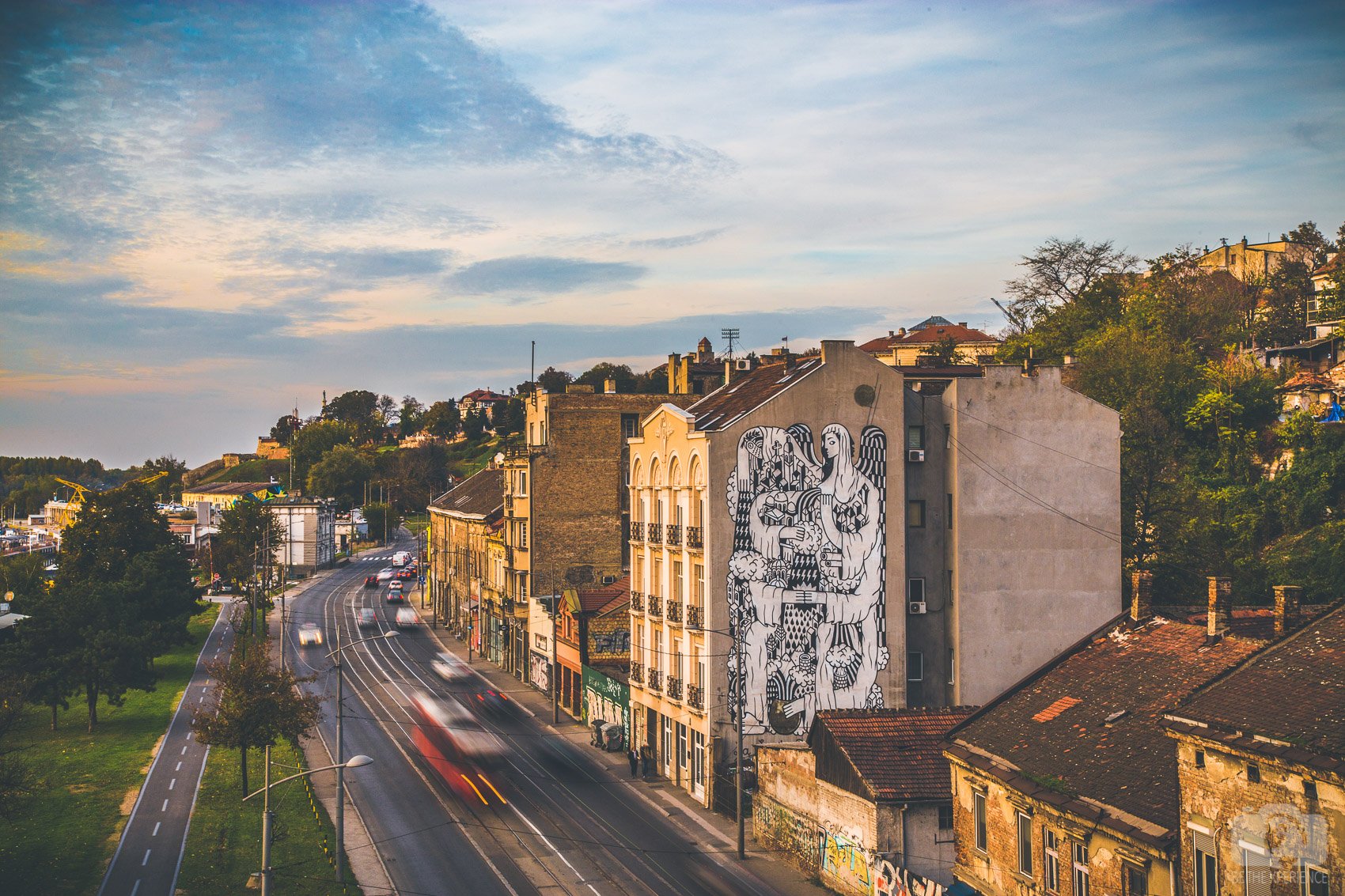 Black-and-white mural on a building beside a curving road near the National Museum in Belgrade