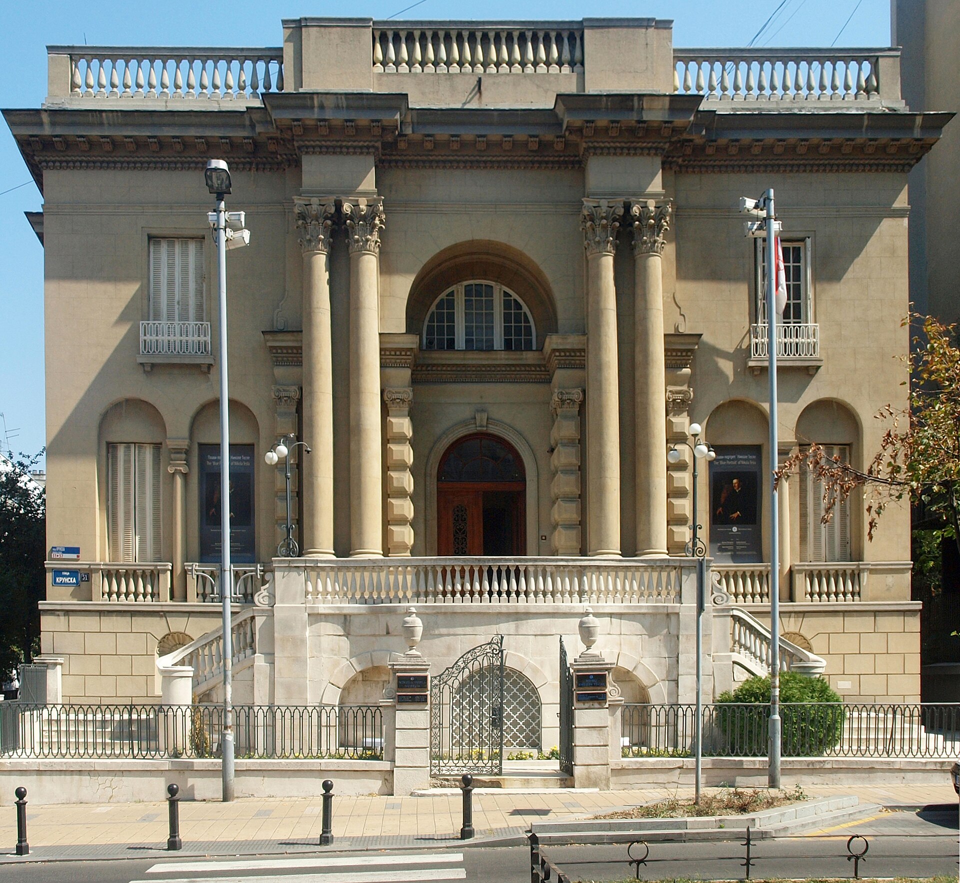 Neoclassical facade of the Nikola Tesla Museum in Belgrade with columns and an arched entrance