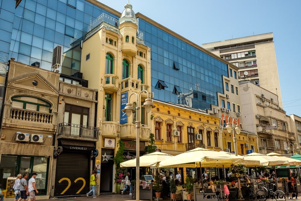 Pedestrian street in Niš with historic façades, glass-fronted buildings, and outdoor café seating