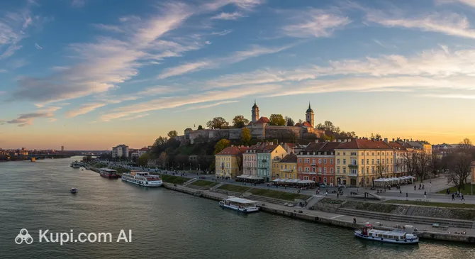 Petrovaradin Fortress above the Danube waterfront in Novi Sad with colorful riverside buildings and boats