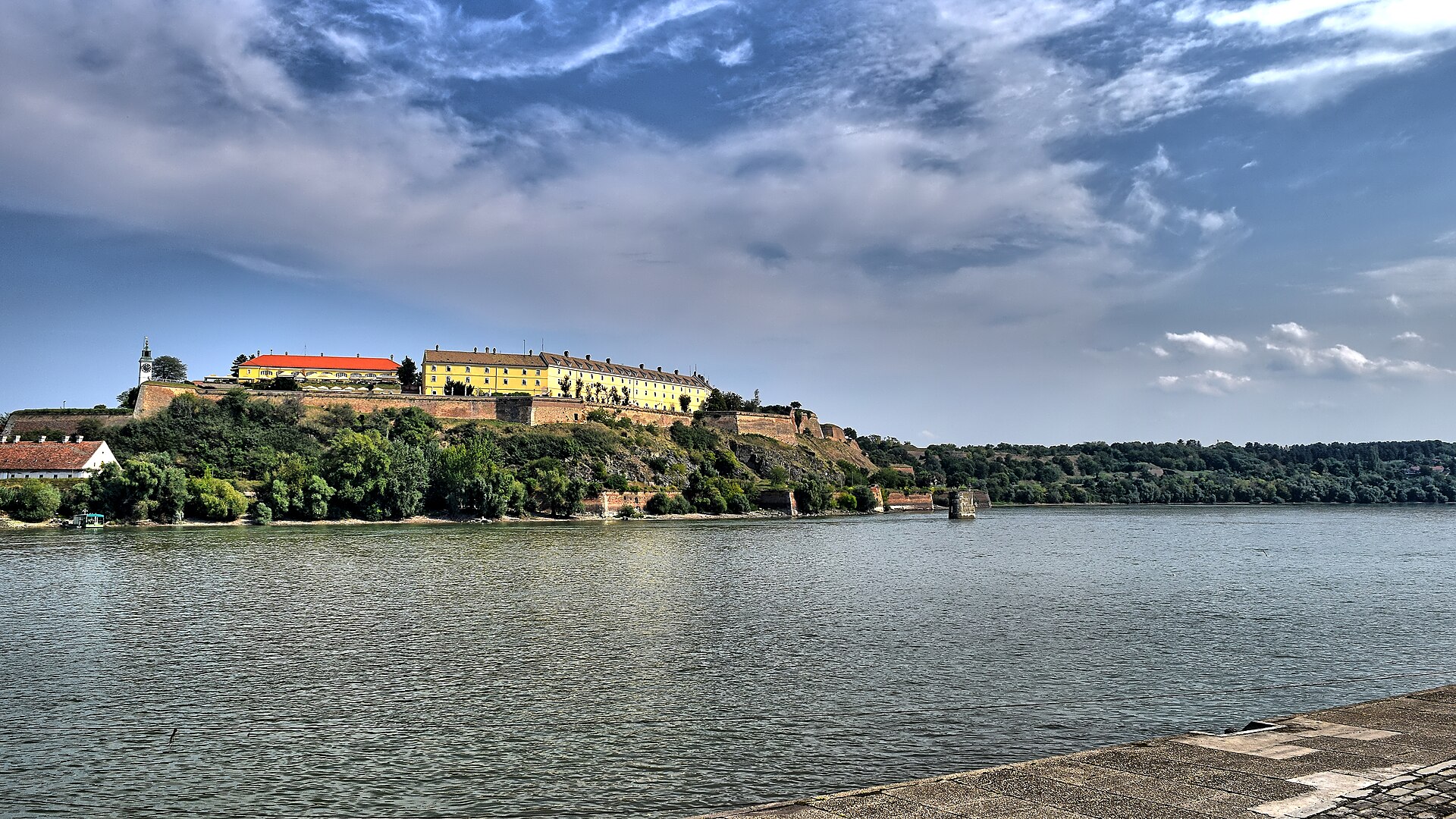 Petrovaradin Fortress with yellow buildings and stone walls above the Danube River