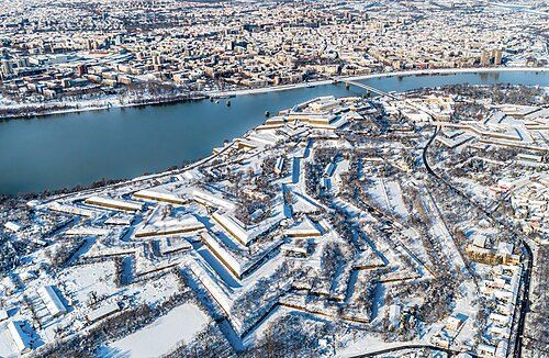 Snow-covered Petrovaradin Fortress above the Danube with Novi Sad spread across the far bank