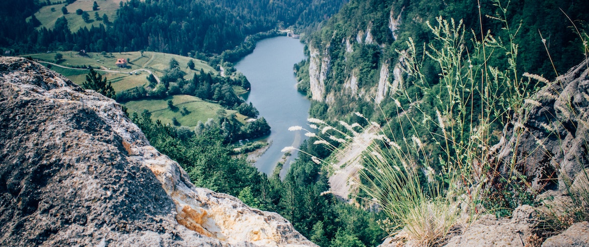 Winding river between limestone cliffs and green fields, seen from a rocky overlook in Serbia