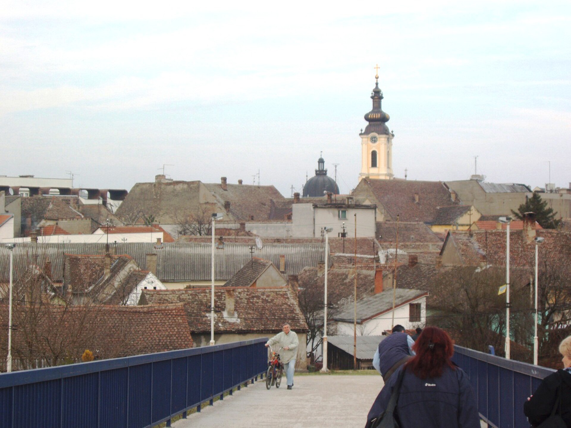 Riverside cityscape with buildings and trees along the bank in Sremska Mitrovica