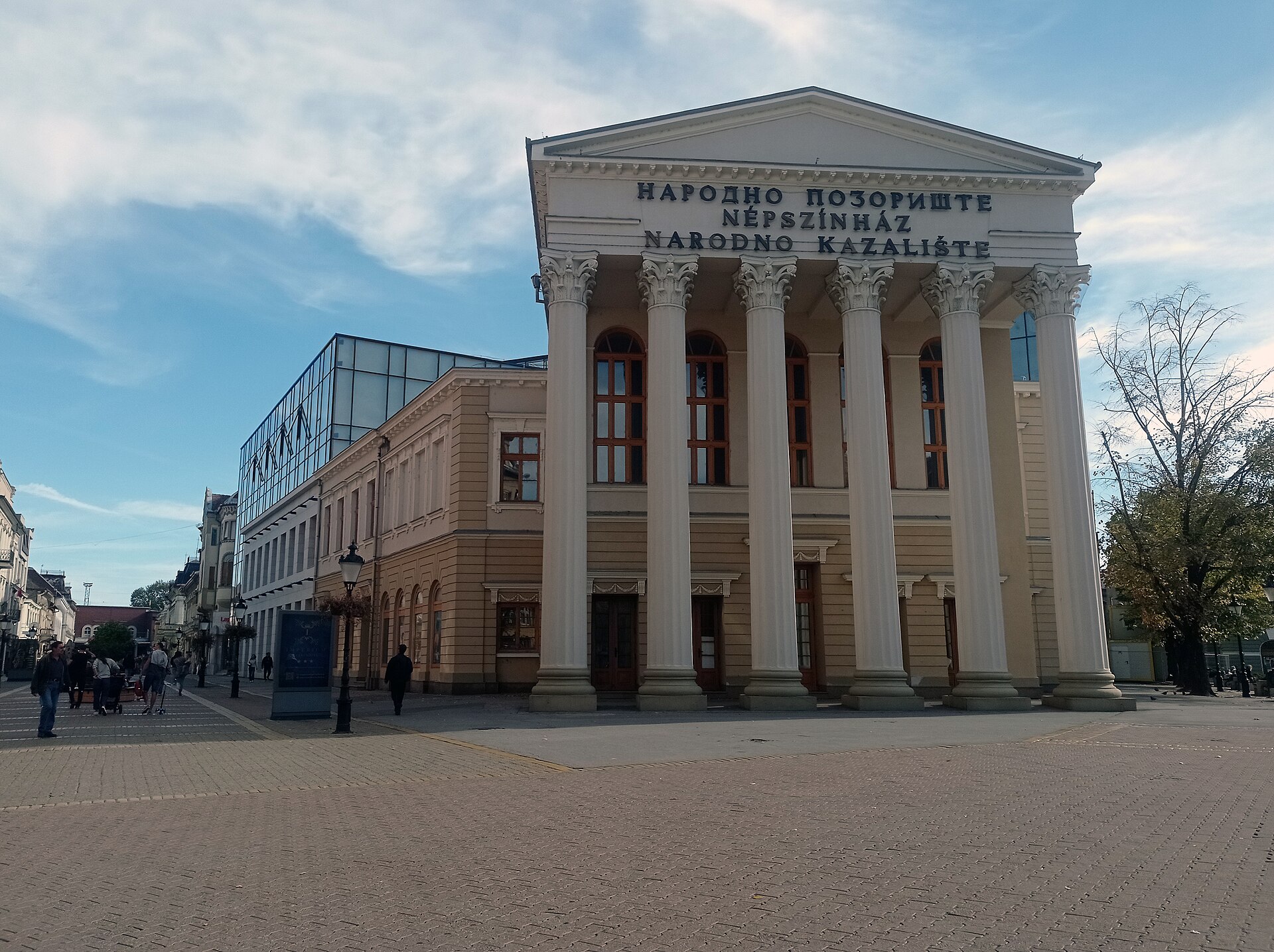 National Theatre building with tall columns and multilingual signage in Subotica's square