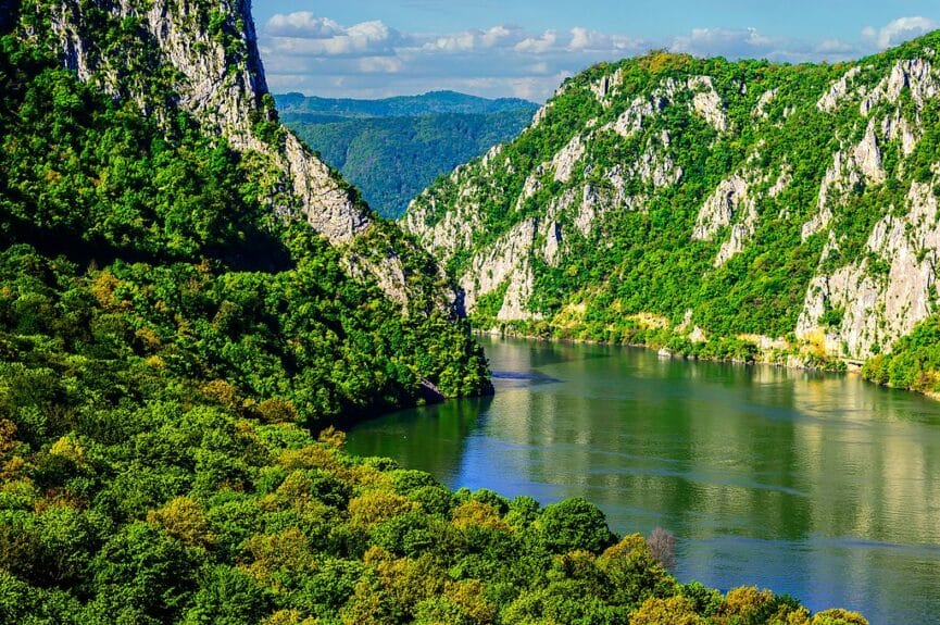 Danube River winding between steep forested limestone cliffs in Djerdap National Park