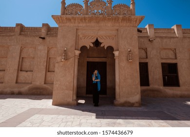 Person standing under an ornate arched doorway of a sandy-toned building in Djerdap National Park