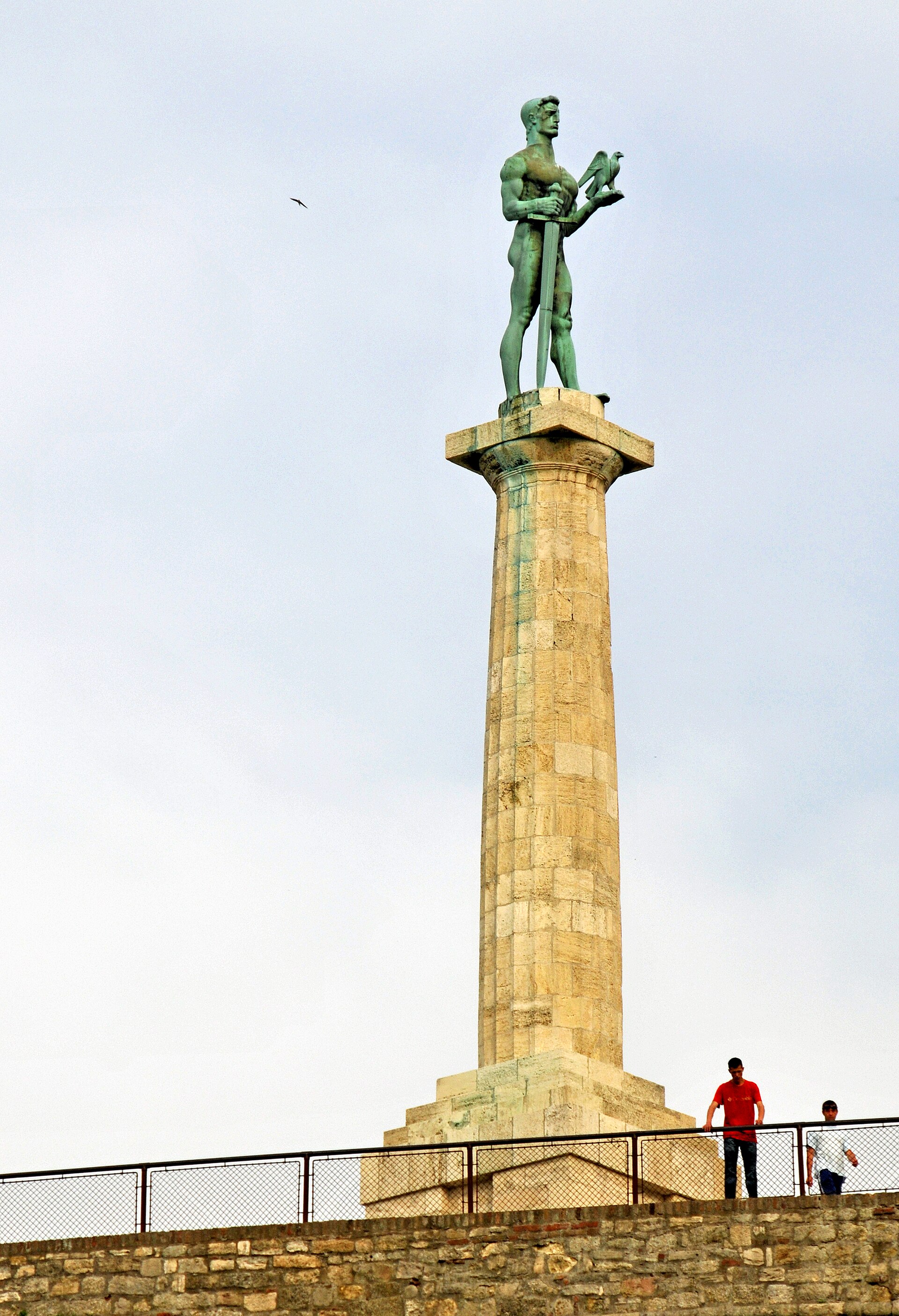 Victor Monument standing on a tall stone column at Kalemegdan in Belgrade, with visitors below