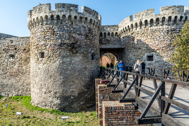 Wooden bridge approaching stone fortress walls and a round tower in Vinča, near Belgrade