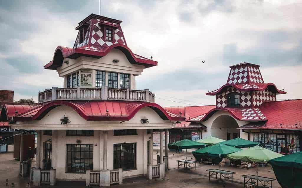 Market building with red patterned roofs and green umbrellas in Zeleni Venac, Belgrade