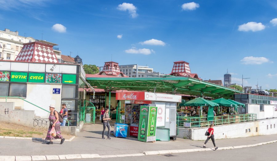 Covered market kiosk with green awnings and sidewalk seating at Zeleni Venac, Belgrade