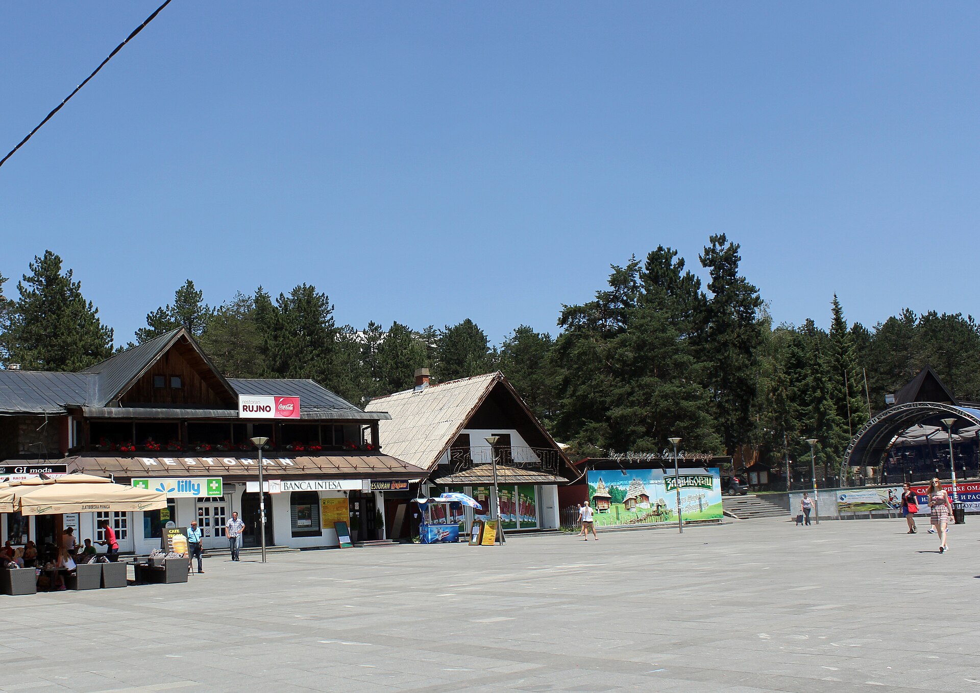 Paved plaza with restaurants, shops, and pine trees in Zlatibor