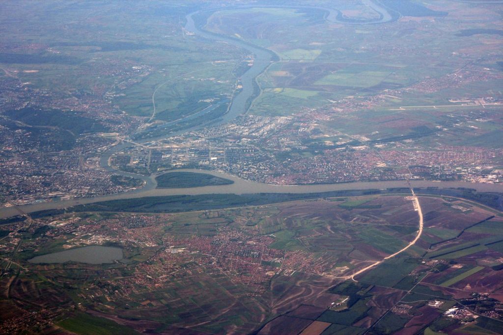 Aerial view of Belgrade at the confluence of the Sava and Danube rivers with neighborhoods and farmland