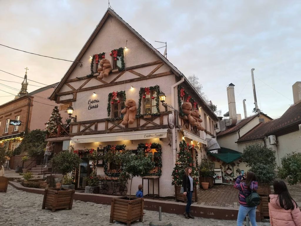 Teddy bear decorated cafe on a cobblestone street in Zemun with Christmas garlands and lights
